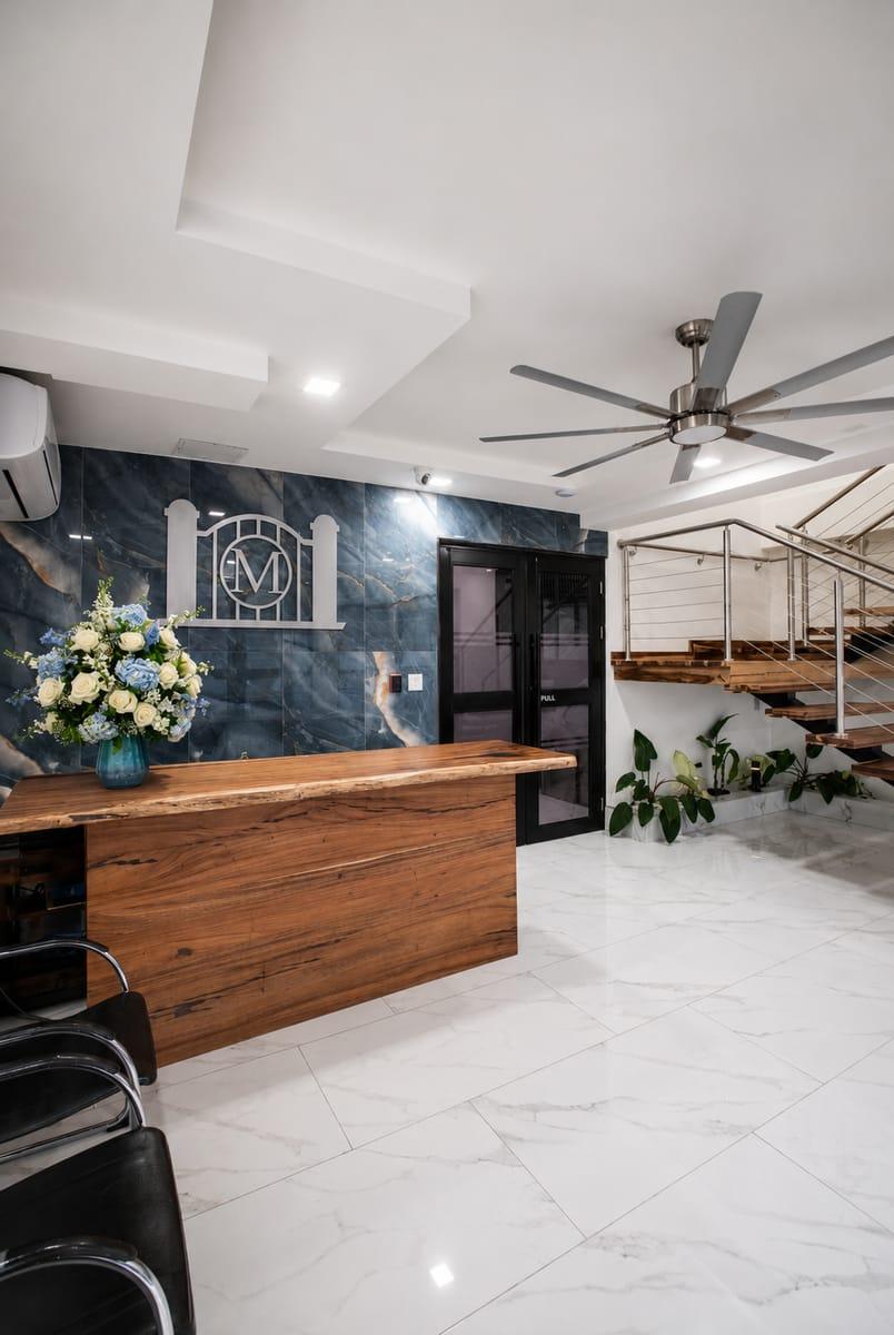 Morgan's Funeral Home reception desk with a fresh floral arrangement set against the slate M emblem wall